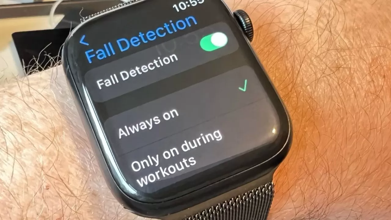 Smartwatch on a person's wrist displaying Fall Detection settings, showing the feature switched on with options for Always on and Only on during workouts
