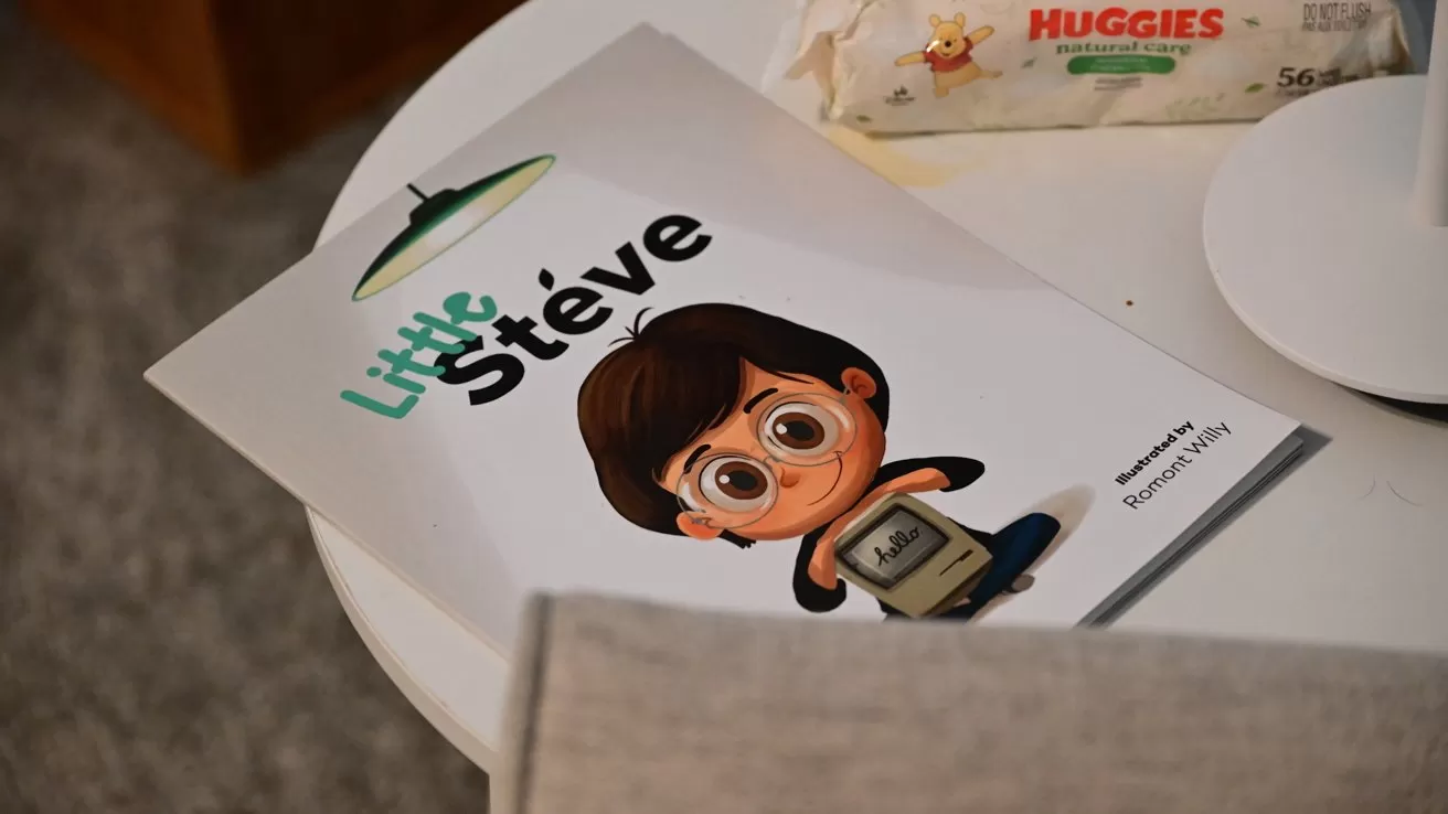 Children's book titled Little Steve on a white table, featuring a cartoon boy with large eyes holding an old computer, with a package of Huggies baby wipes in the background