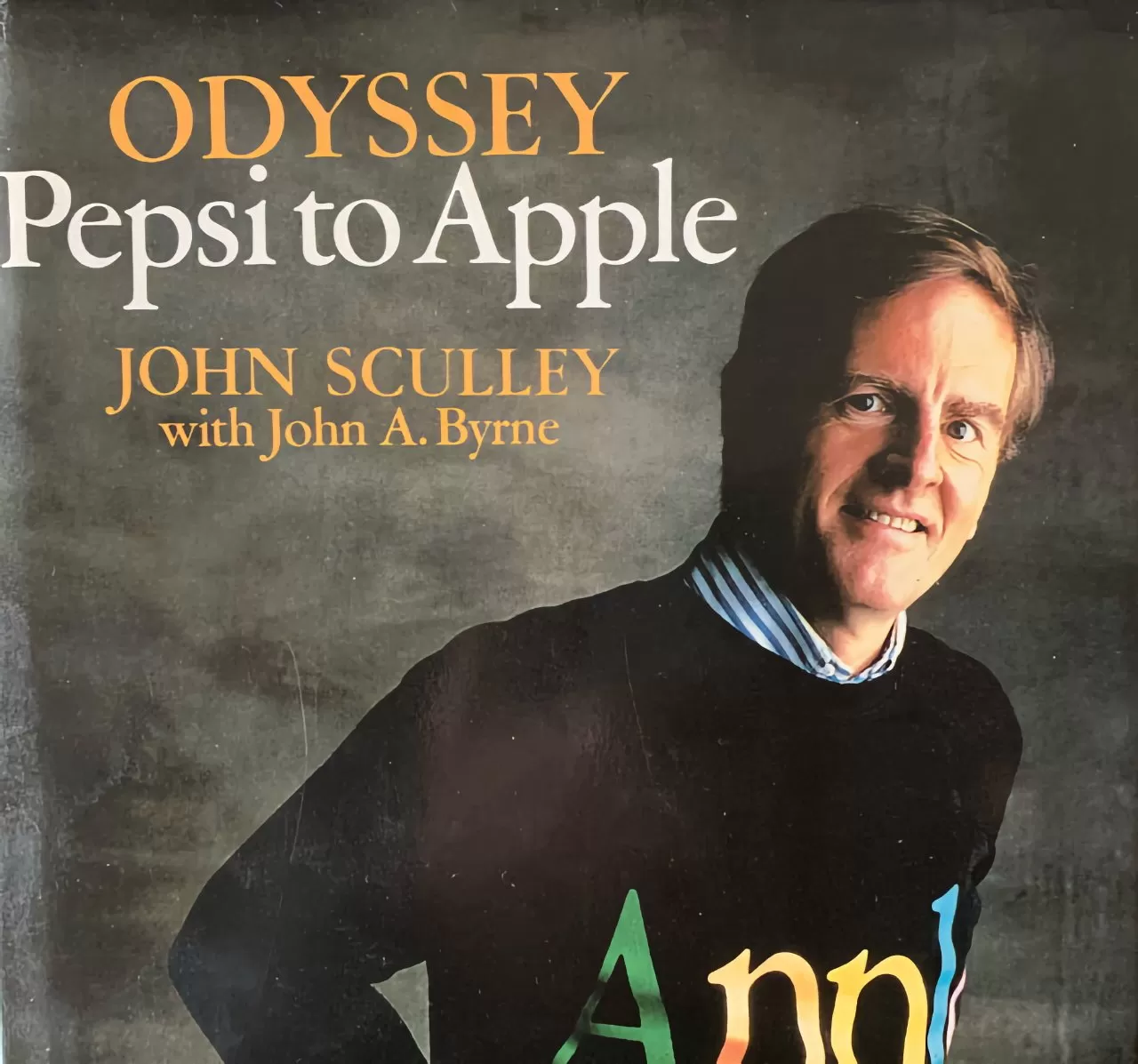 Man in a black sweater with colorful text on front cover of book titled 'Odyssey: Pepsi to Apple' by John Sculley with John A. Byrne.