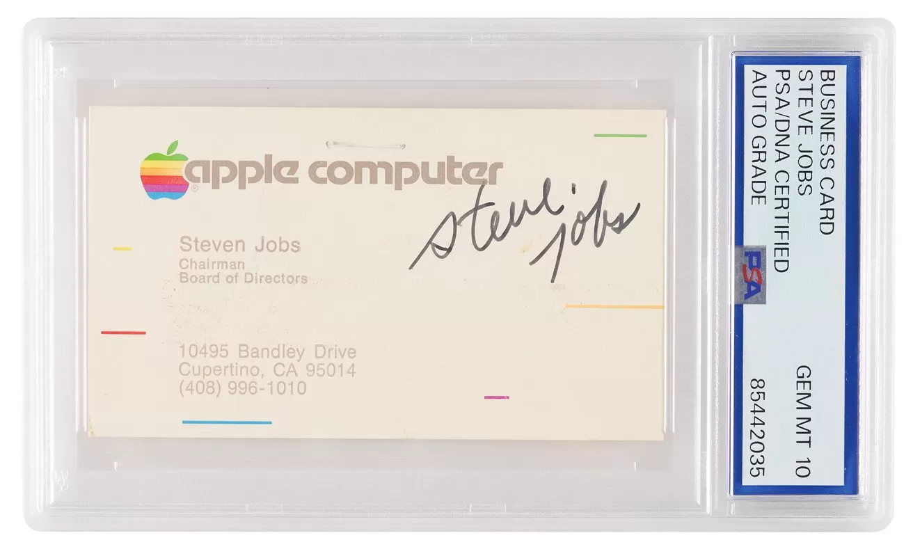 Encased Apple Computer business card featuring multicolor apple logo, Steven Jobs contact details, and prominent black autograph, graded and sealed in a clear plastic holder with certification label