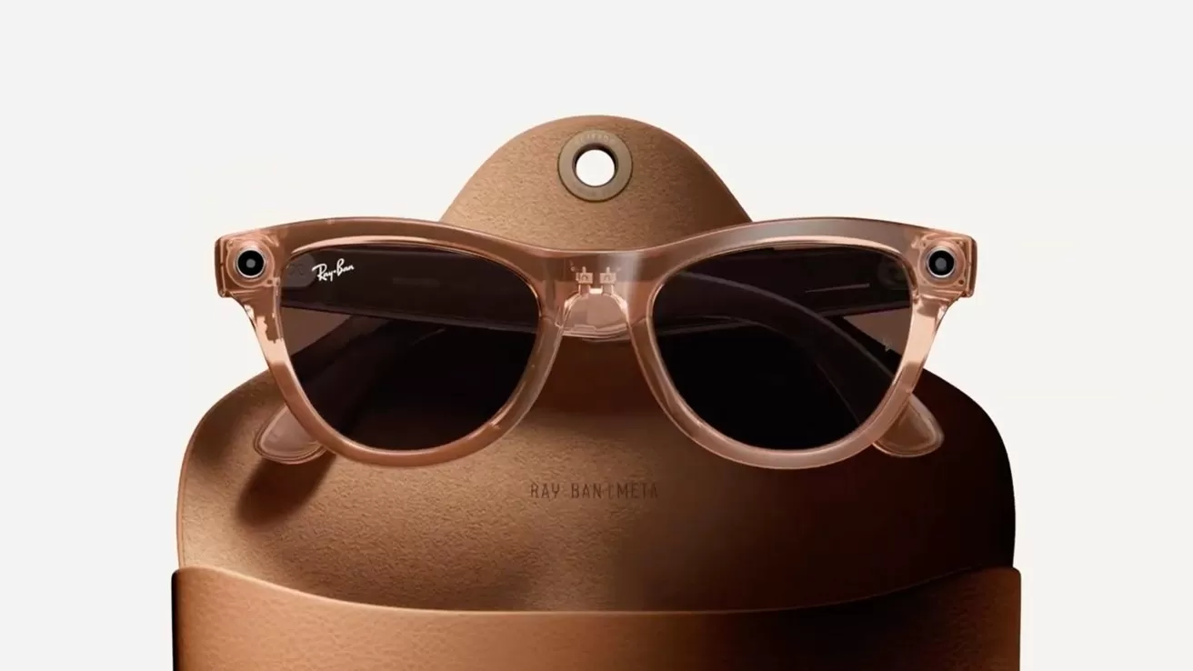 Beige smart sunglasses with dark lenses and small cameras in the corners, resting in an open tan leather case against a plain light background