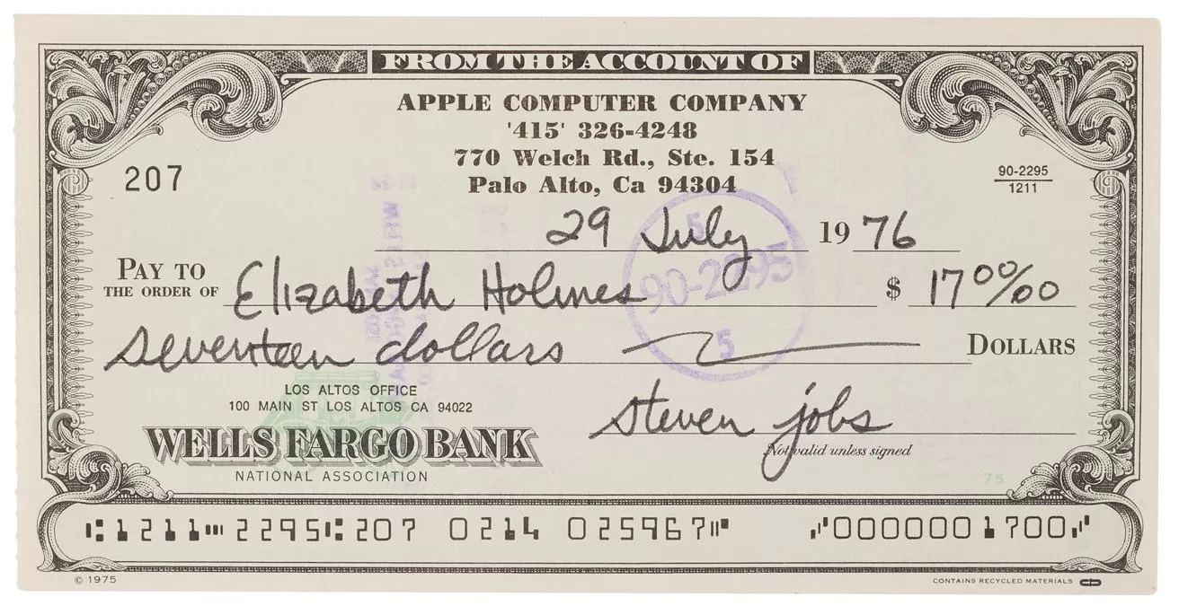 Vintage Wells Fargo Bank check from Apple Computer Company, dated July 29, 1976, made out to Elizabeth Holmes for seventeen dollars, featuring ornate border design and signed by Steven Jobs