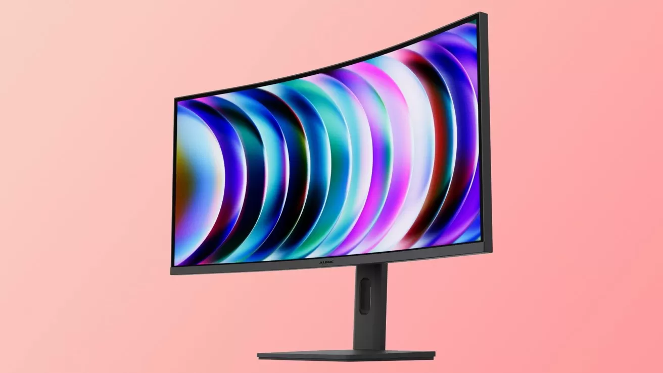 Curved widescreen computer monitor on a stand, displaying colorful abstract light rings on a gradient pink background, viewed from a slight angle.