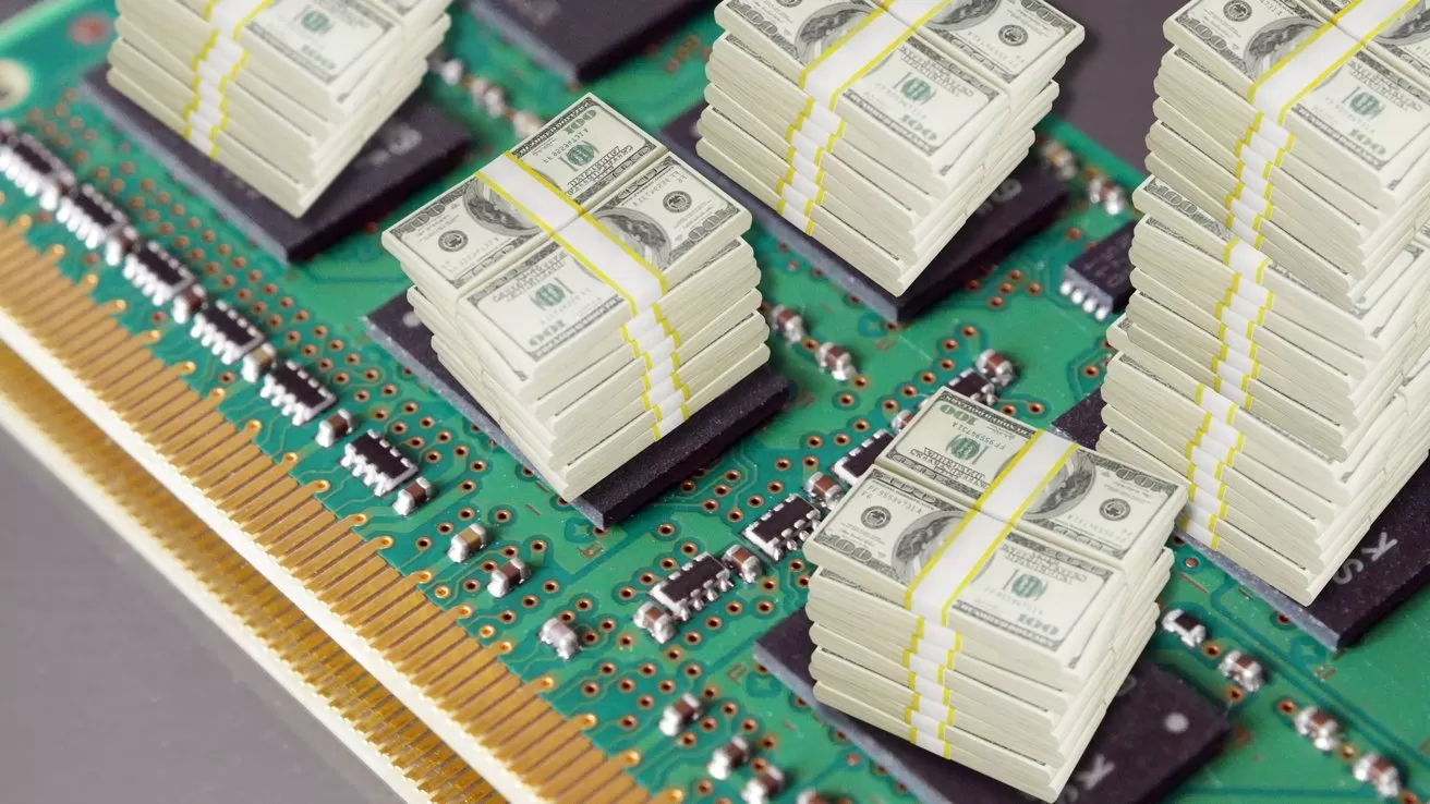 Stacks of US hundred dollar bills arranged in tall piles on a computer circuit board, symbolizing expensive or high value technology and data processing costs