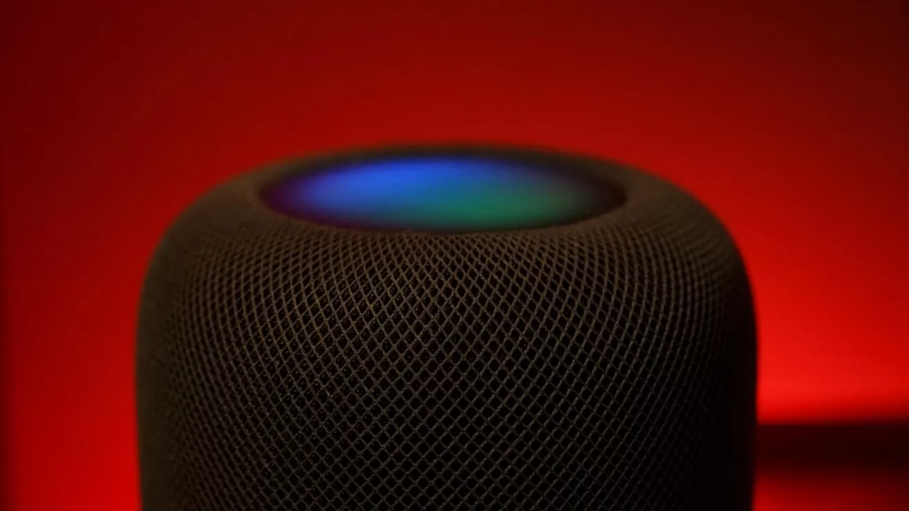 Smart speaker with dark mesh exterior, glowing multicolored light on top, set against a vivid red background