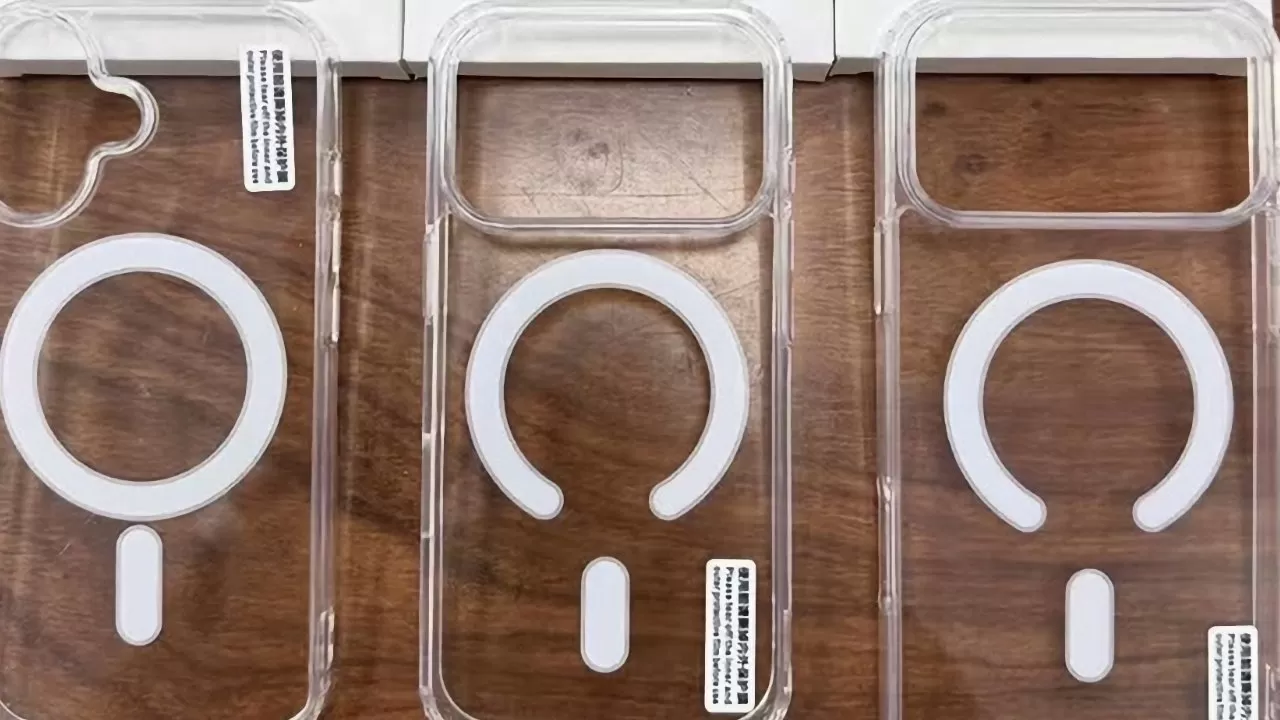 Three clear smartphone cases with white MagSafe-style circular and vertical alignment markings, arranged side by side on a wooden surface, each shaped for a different camera layout