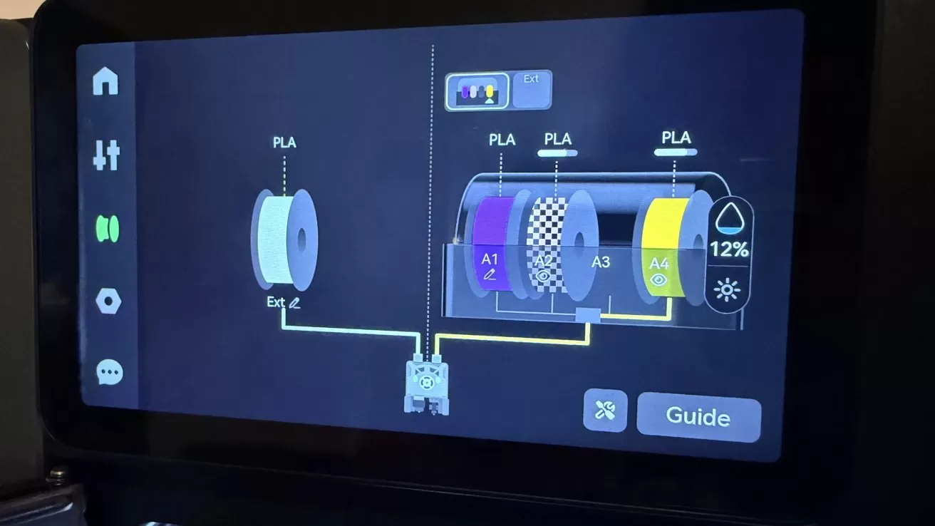 Touchscreen control panel of a 3D printer showing PLA filament spools in different colors, labeled A1 to A4, with a 12 percent humidity indicator and navigation icons on the left