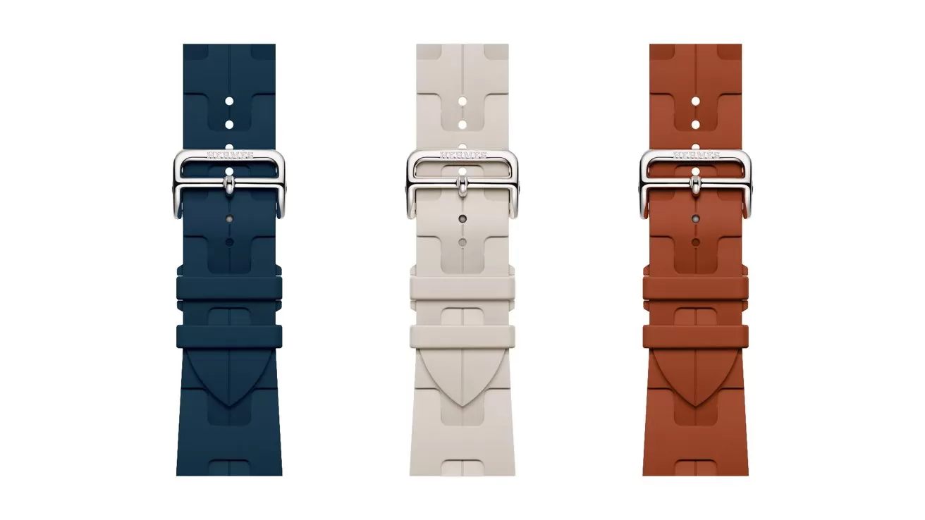 Three rubber watch straps in navy blue, light beige, and rust brown, each with a silver buckle, displayed vertically side by side on a plain white background.