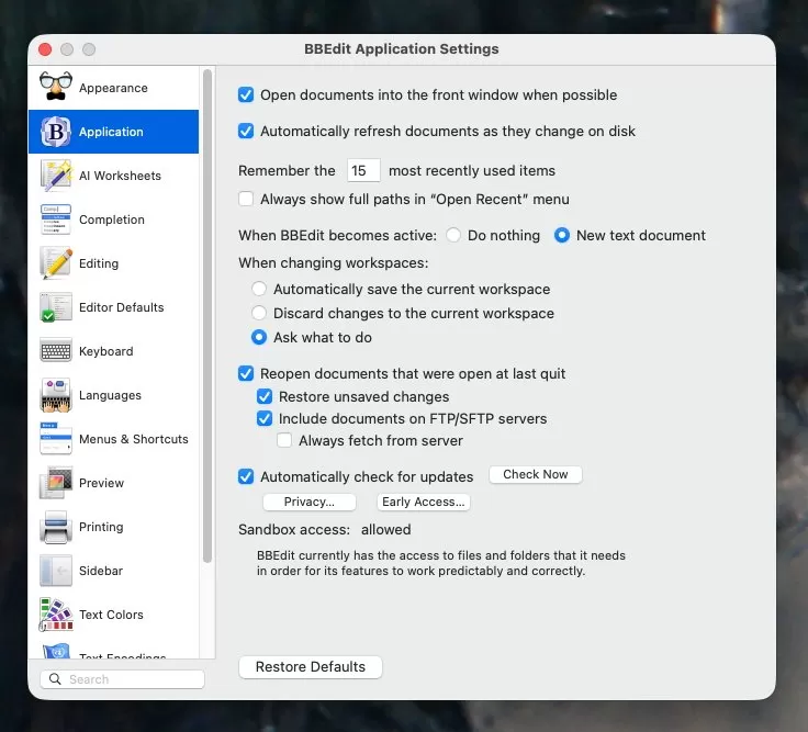 BBEdit Application Settings window on macOS showing sidebar categories and main panel options for opening documents, changing workspaces, reopening documents, automatic updates, sandbox access, and a Restore Defaults button