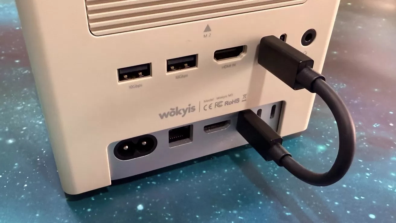 Back of a computer with various ports including USB, HDMI, power, and network. A cable is plugged into an HDMI port, set on a starry background.