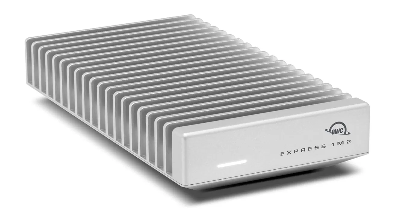 Silver rectangular external SSD with large vertical cooling fins on the top and sides, a small front LED indicator, and the label OWC Express 1M2 on the front panel