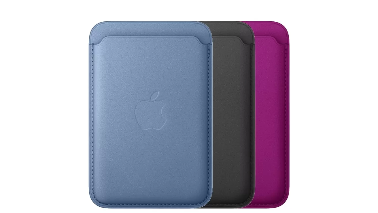Three Apple MagSafe leather card wallets standing side by side, in blue, black, and magenta colors, showing stitched edges and embossed Apple logo on the front.