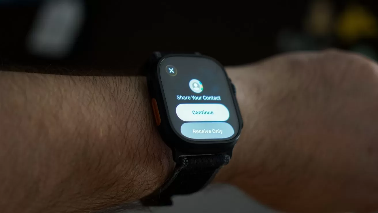 Smartwatch on a person's wrist displaying a screen with options to share contact information, featuring buttons labeled Continue and Receive Only