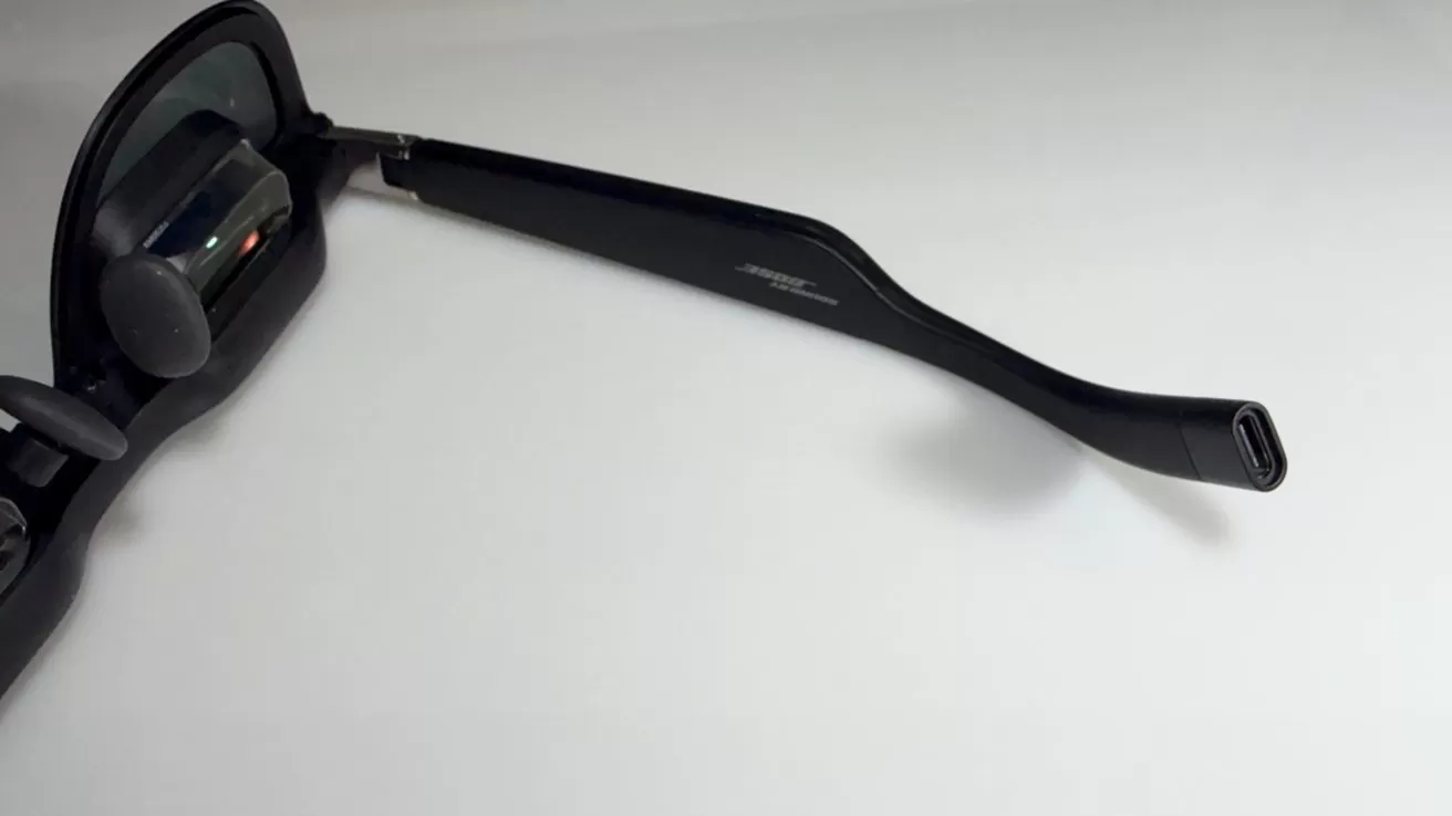 Sunglasses with sleek black frames featuring integrated technology on a clean, white background. Right arm extended towards the viewer.