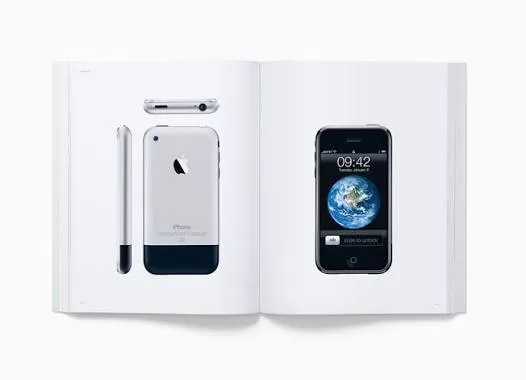 Open book displaying early iPhone product photos, including front view with Earth wallpaper, back view, side profile, and top edge, all on clean white pages against a white background