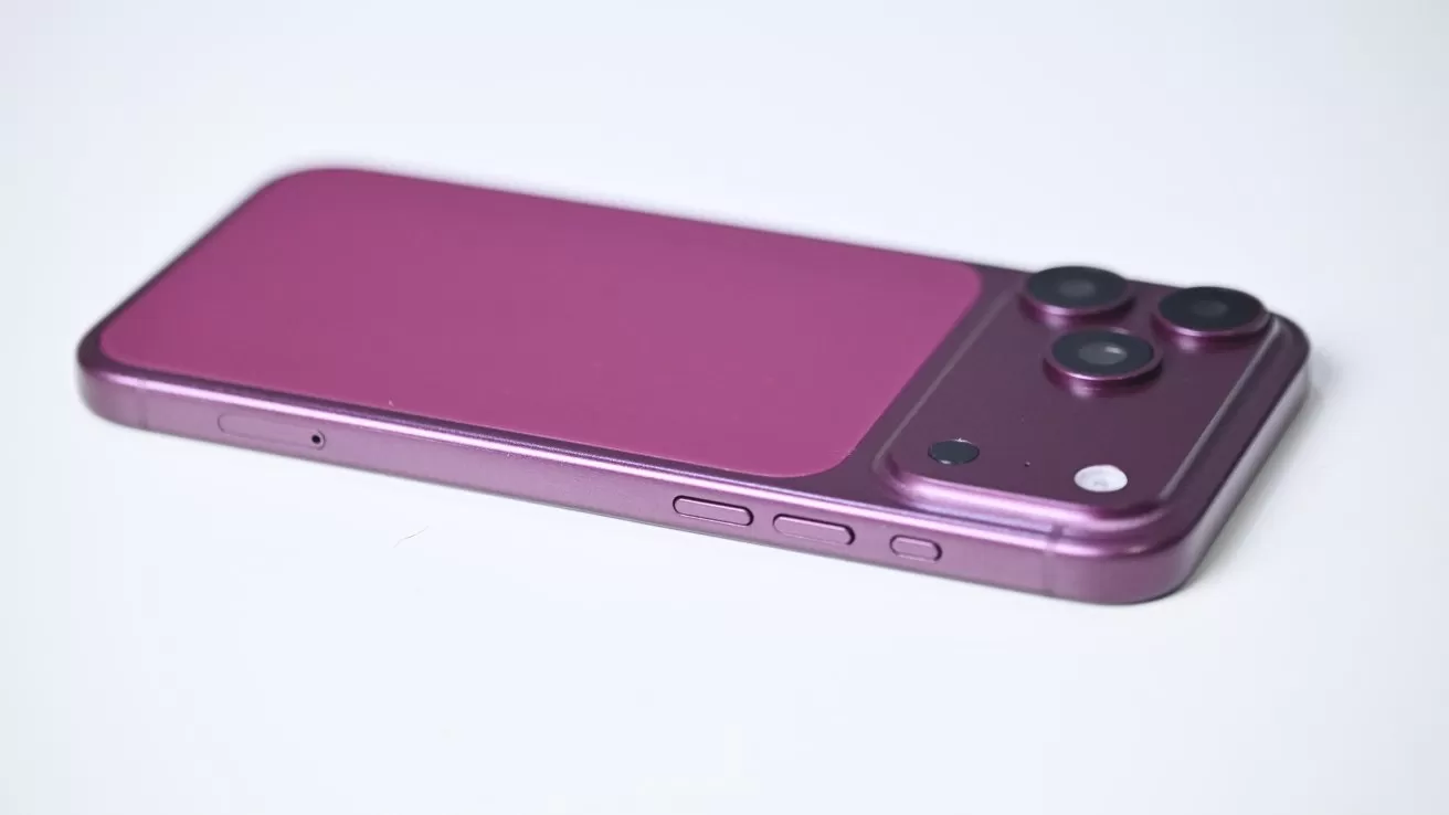 Purple smartphone lying face down, showing a dual camera bump with flash in the top corner, smooth matte back, and side buttons visible against a plain light background