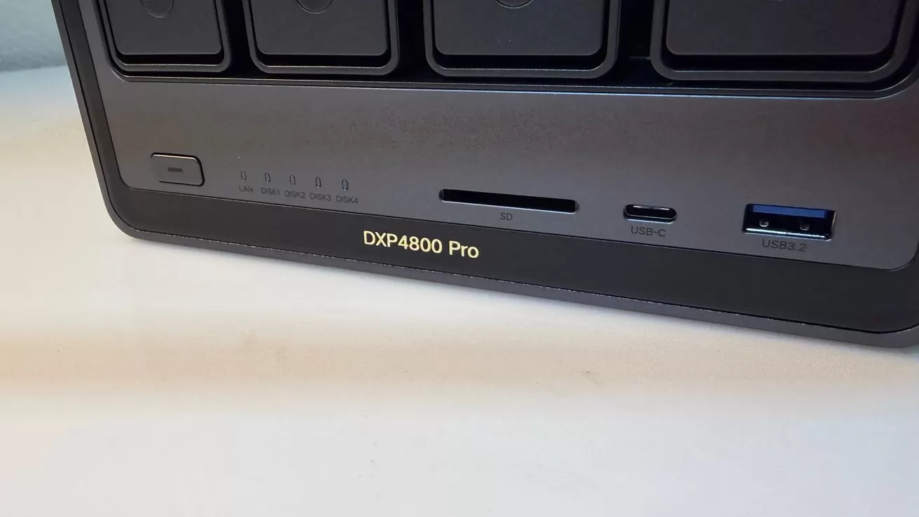 Front panel of a DXP4800 Pro device showing status LEDs, power button, SD card slot, USB-C port, and blue USB-A port on a dark rectangular enclosure